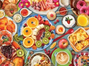 Breakfast Table -palapelissä kahvi, värikkäät hedelmät, mehut ja muut herkut on katettu aamiaispöytään. Palapelissä on 1000 palaa. Koko on 67 x 49 cm.