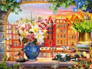 Sojourn in Amsterdam palapeli on Schmidtin 1000 palan palapeli, jonka kuvassa näkyy amsterdamilaisia taloja. Ikkunalaudalla upea kukkakimppu, jossa on liljoja ja ruusuja.